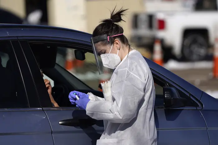A tester prepares to administer a swab test at a drive-in COVID-19 testing site in Federal Heights, Colorado.
